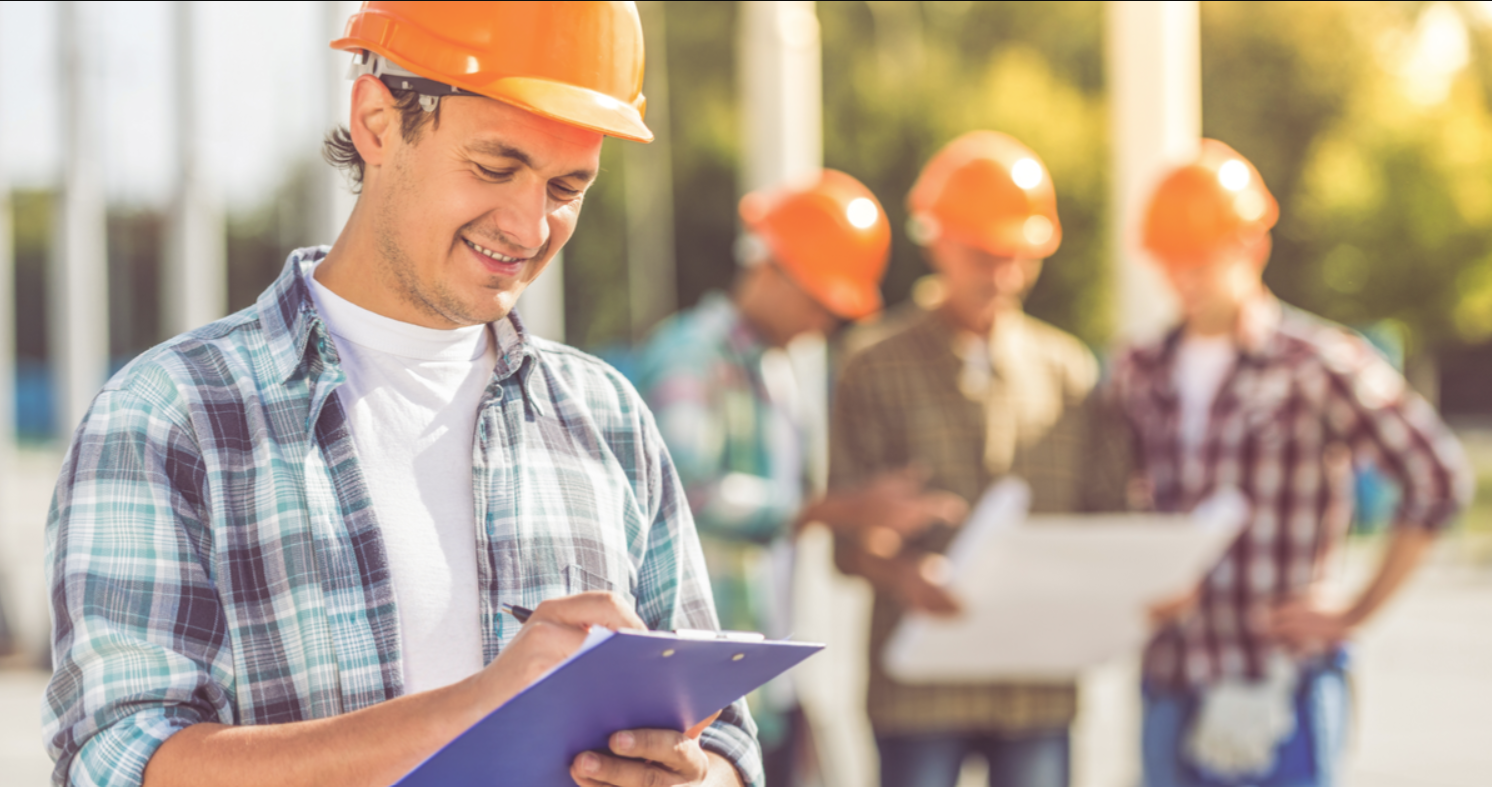 Pre-Selecting a Contractor for your Development Project - contractors in orange hard hats looking at development plans